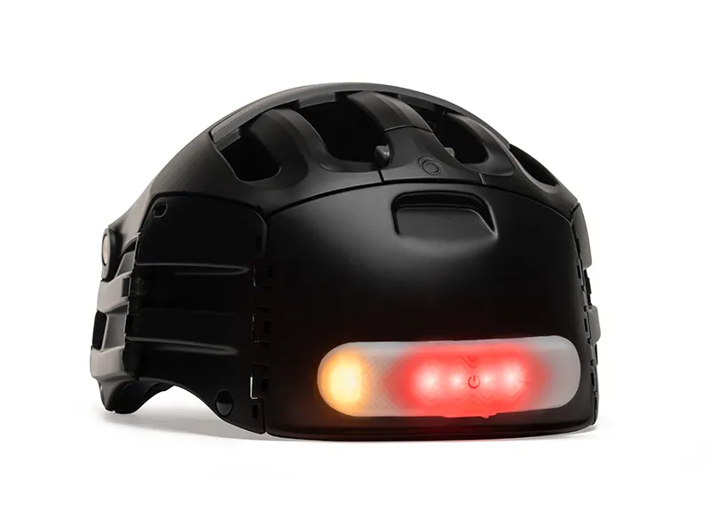 Casque de vélo noir avec éclairage LED rouge photographié sur fond blanc